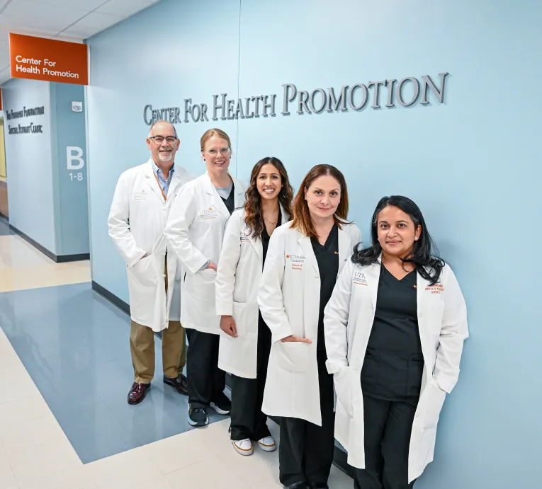 Faculty and leadership associate with the Center for Health Promotion stand for a group photo under the clinic’s name.